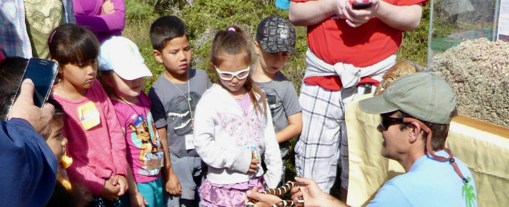 Gage Dayton shows a snake to elementary children from Marina, CA.